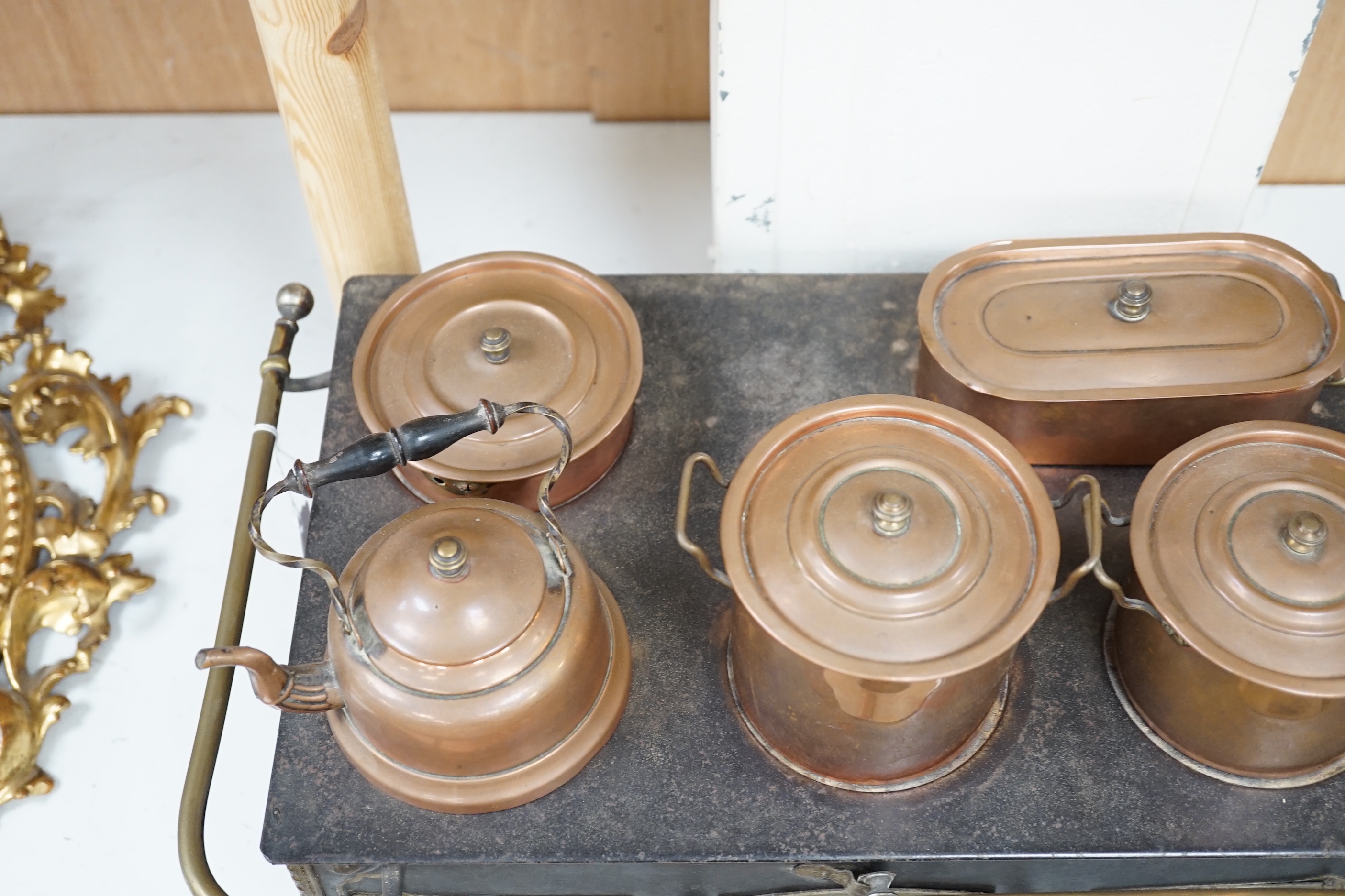 A Continental iron child's toy range/ stove, with a collection of copper fitted pans and a similar kettle, range 46cm wide x 28cm deep x 18.5cm high